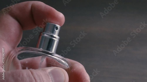 Spraying perfume from a close perspective to capture the essence of fragrance on a wooden surface