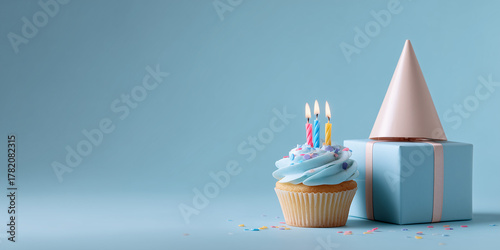 A delightful birthday cupcake with candles, gift box, and party hat. The scene evokes a sense of joy and celebration. 
