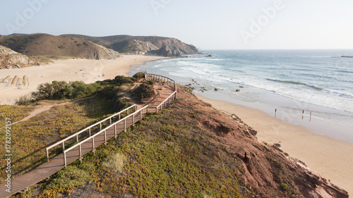 Wooden boardwalk leading to praia da amoreira beach in aljezur, portugal