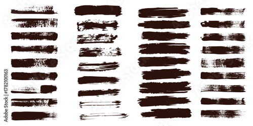 Collection of dark brown distressed paint brush strokes and splatters on a white background
