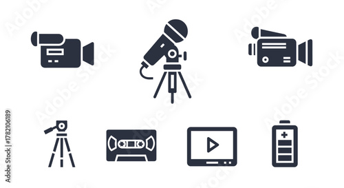 Collection of six solid, filled icons representing video recording and related equipment, including a video camera, microphone on a tripod, vintage video tape, a monitor with a play button, and a