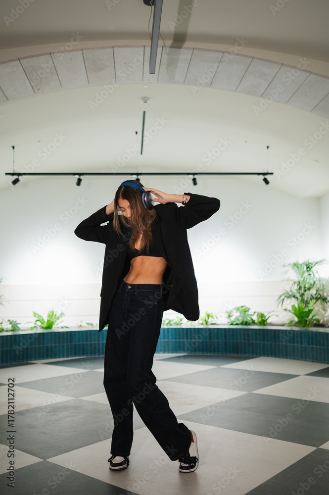Fototapeta premium Young woman dancing urban style listening music