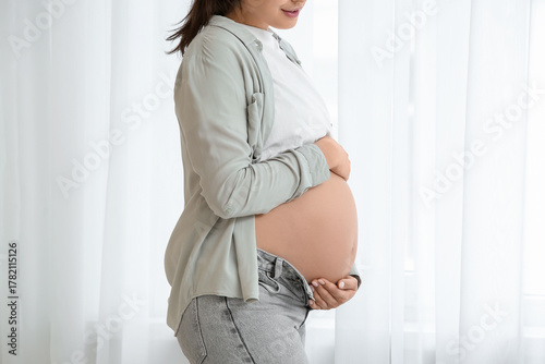 Young pregnant woman near w...