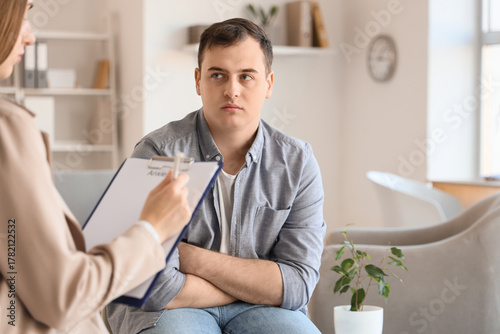 Upset male drug addict visiting psychologist in office