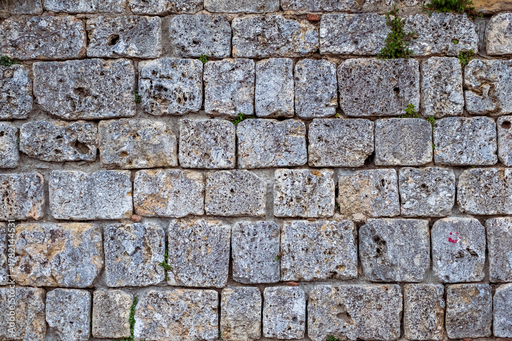 Fototapeta premium Durable stone wall featuring a textured surface with a unique pattern, showcasing the beauty of outdoor paving and design elements in a functional way with copy space