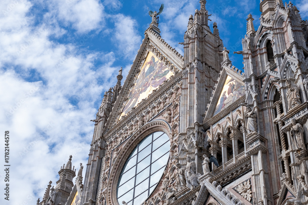 Obraz premium Majestic Siena cathedral in Italy, facade showcasing intricate architectural details under a bright blue sky, inviting travelers to explore ancient beauty and rich history with copy space