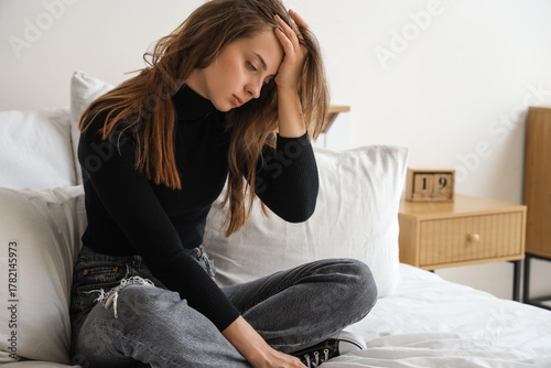 Sad young woman sitting in ...