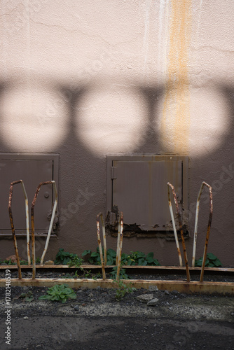 丸い光が当たっている壁と、自転車置き場