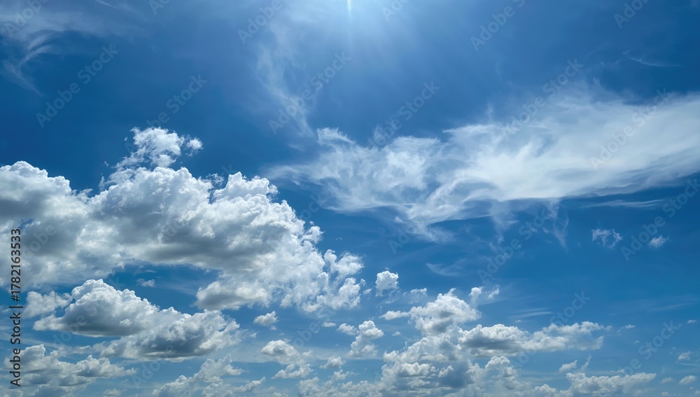 Obraz premium Beautiful sky filled with fluffy white clouds under bright sunlight, ideal for outdoor activities