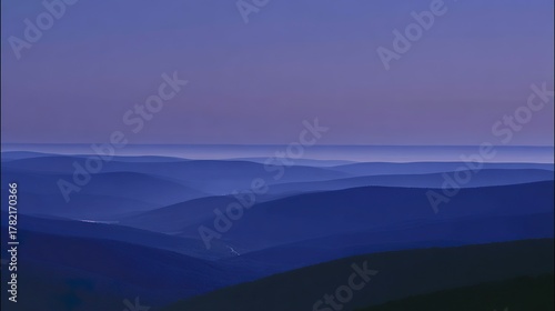 Minimalist blue mountain landscape at dusk, perfect wallpaper background with smooth purple-blue gradients, serene digital screen design, calming abstract scenery for phones and desktops
