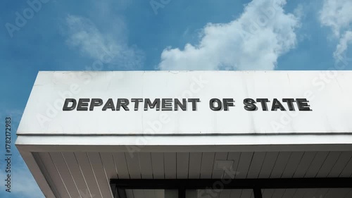 Department of State word sign displayed on a massive governmental building under a clear blue sky, symbolizing foreign policy, diplomacy, international relations, government, security, and global