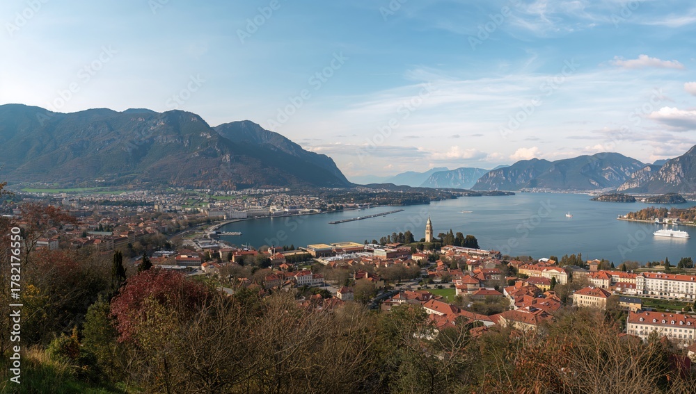 Fototapeta premium Wide-angle scene of a stunning lake surrounded by autumn foliage and charming townscape
