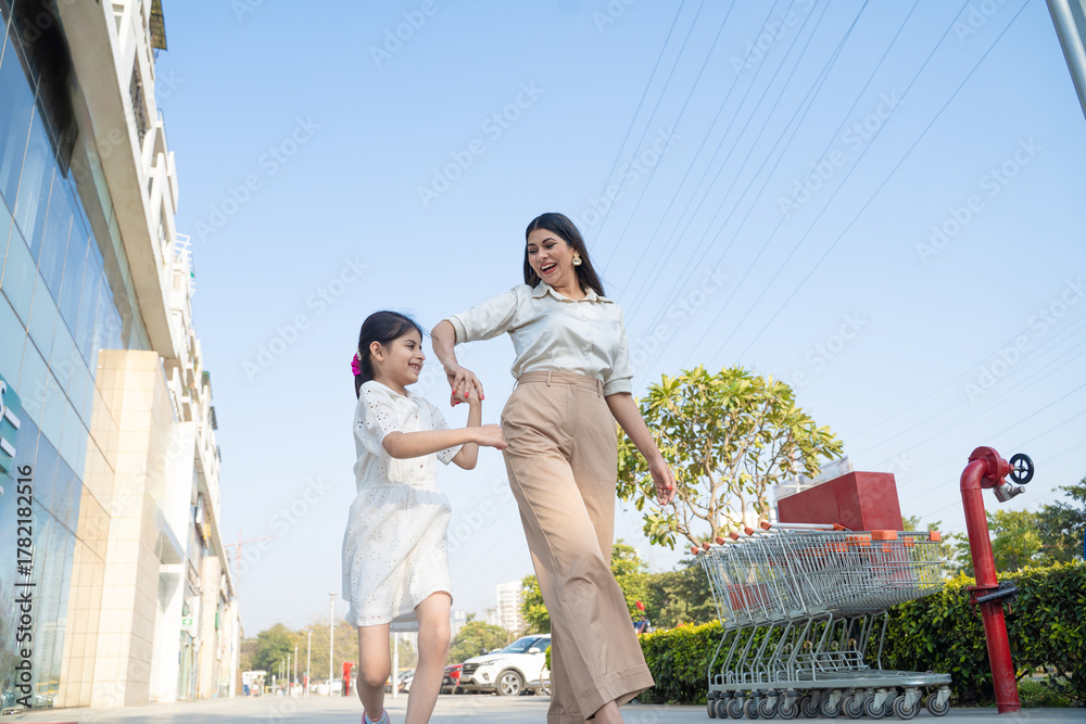 Naklejka premium Indian woman with her little girl walking on city street.