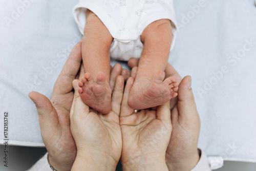 Newborn baby feet in parents hands symbolizing love, care and family protection
