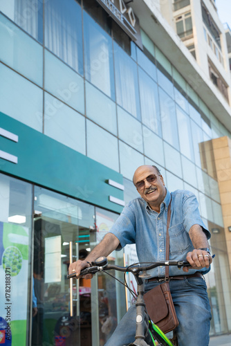 Wallpaper Mural Indian senior man riding bicycle on city street. Torontodigital.ca