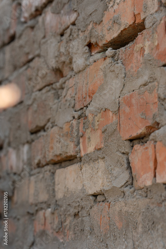 Rough Brick Wall With Mortar And Cement In Construction Setting. Vertical photo, selective focus