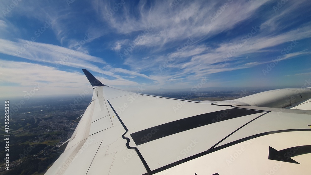Obraz premium View from Airplane Window with Wing and Blue Sky