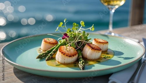 Seared scallops with asparagus and microgreens on a turquoise plate
