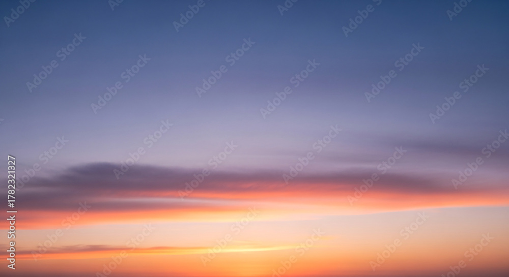 Obraz premium Vibrant Sunset Sky with Wispy Clouds and Gradient Colors Over Horizon