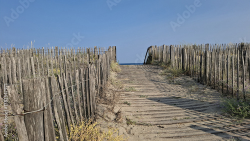 Un chemin en caillebotis en bois menant à la plage des Trois Digues à Sète