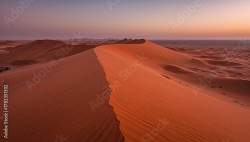 Vast Sahara Desert landscape featuring a prominent dune at dusk, showcasing natural beauty and wilderness