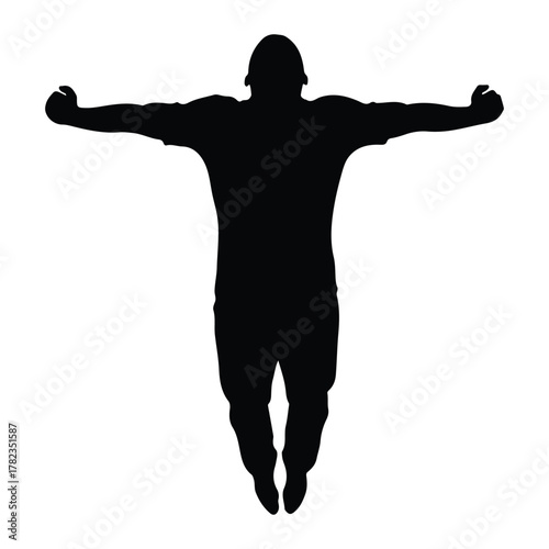 Silhouette of a person with arms outstretched in mid-air