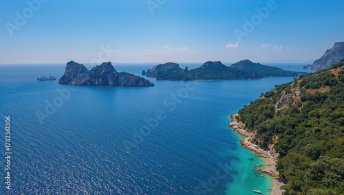 Fototapeta Naklejka Na Ścianę i Meble -  Aerial view of shimmering water resembling a sapphire, with a wide blue sky over the stunning coastline and beautiful beaches, seasonal change