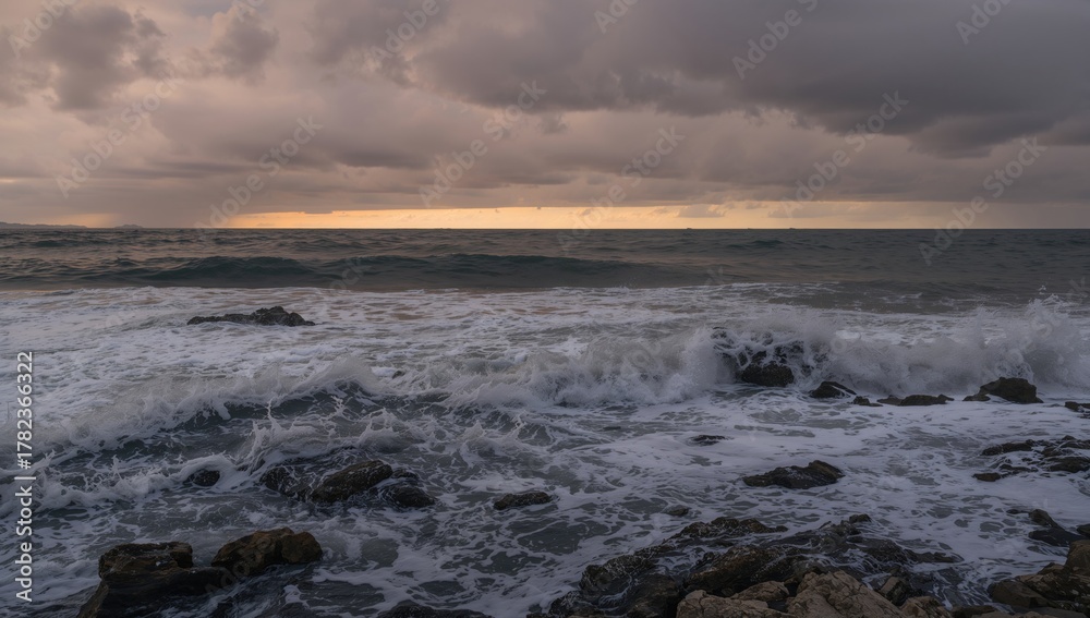 Fototapeta premium Vertical image of ocean waves hitting rocky shoreline, showcasing erosion risk