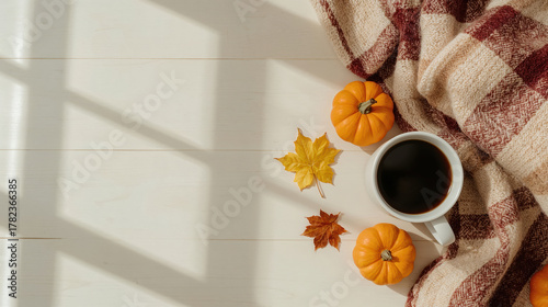 Tazza di caffè con mini zucche e foglie autunnali accanto coperta a quadri. Generative AI