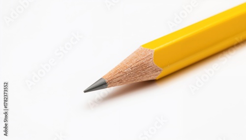 Macro yellow wooden graphite pencil on white background, ideal for educational use