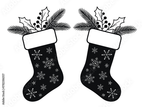 Two black Christmas stockings filled with festive foliage and adorned with snowflakes