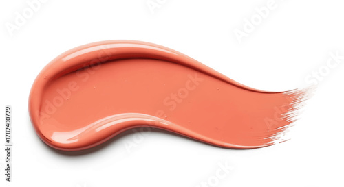 A creamy smear of coral pink lipstick or liquid blush cosmetic product isolated on a white background.