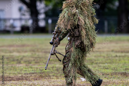 ギリースーツを着て狙撃銃を構える軍人