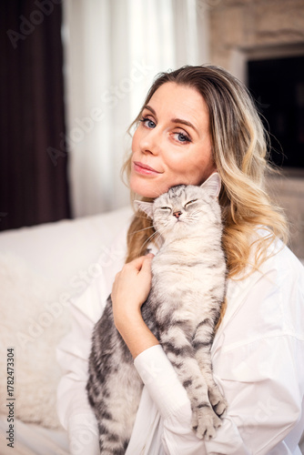 pretty, young woman with her gray cat at home