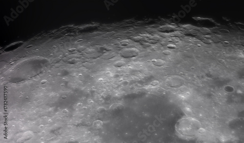 Panoramic view of the Moon surface, showing intricate details of its craters and rugged terrain. The image captures the texture, shadows, and natural formations of the lunar landscape.
