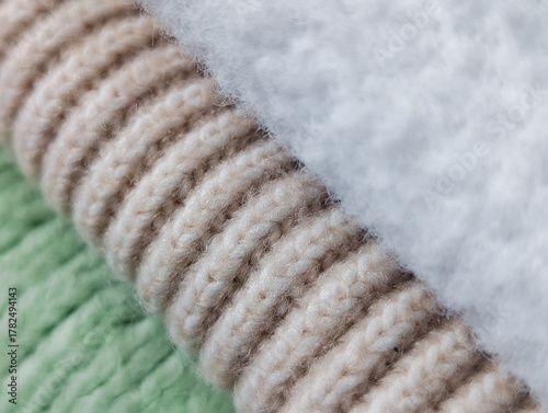 diagonal composition of three rolled cozy fabrics: fleece, ribbed knit and green knit texture