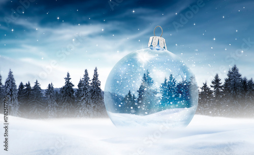 Gläserne WEihnachtskugel mit Wintermotiv in einer Bewaldeten Schneelandschaft