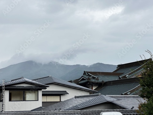Traditional Japanese rooftops in Kawaguchiko with misty mountains in the background
