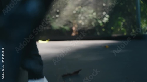 Child Jumping on Outdoor Black Trampoline with Leaves and Debris