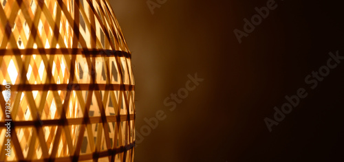 Принти на полотні Illuminated bamboo wicker lampshade casting warm decorative light with geometric