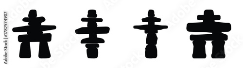 Four inukshuks symbols standing together representing inuit culture and navigation markers