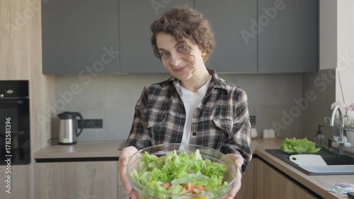 Smiling Woman Holding Fresh Vegetable Salad Bowl In Modern Kitchen