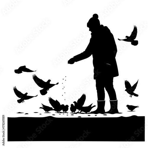 Person feeding a flock of pigeons in winter weather wearing warm hat and jacket in silhouette art