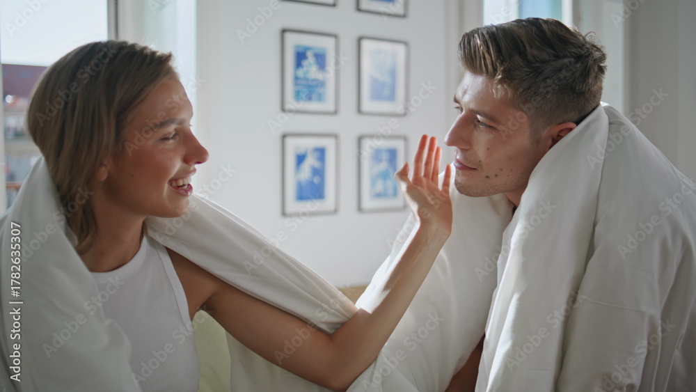 Fototapeta premium Happy girlfriend stroking man face closeup. Joyful lovers in blankets relaxing 