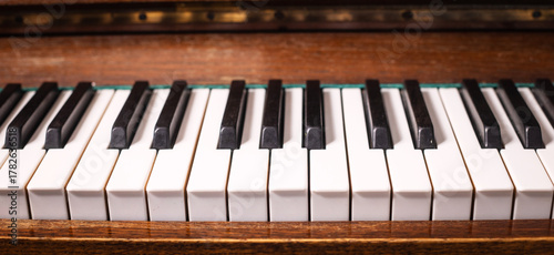 Old piano keys. Close-up of piano keys focused on one note with foreground and background fading into the distance. Musical concept theme