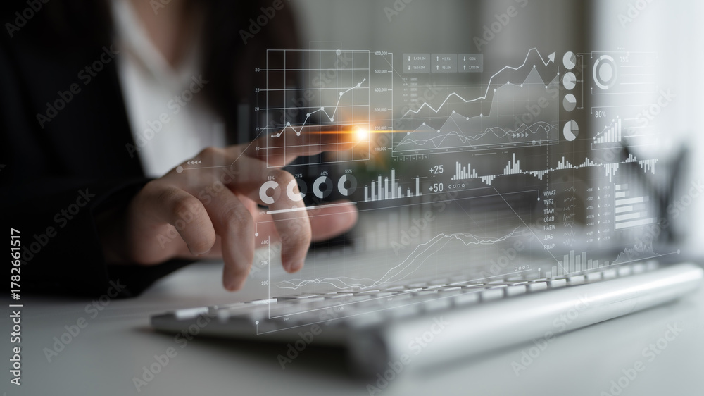 Naklejka premium A business professional uses a laptop to analyze data trends on a digital screen, showcasing financial decision making and strategic planning through modern analytics. Scalp
