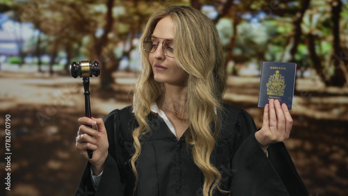 Φωτογραφία Blonde woman in judge uniform holds canadian passport and gavel in a green park setting, signifying the intersection of law and travel outdoors