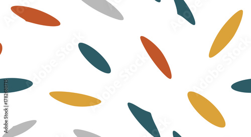 An abstract pattern featuring scattered, colorful shapes on a white background. The shapes are oval, teardrop, and geometric.