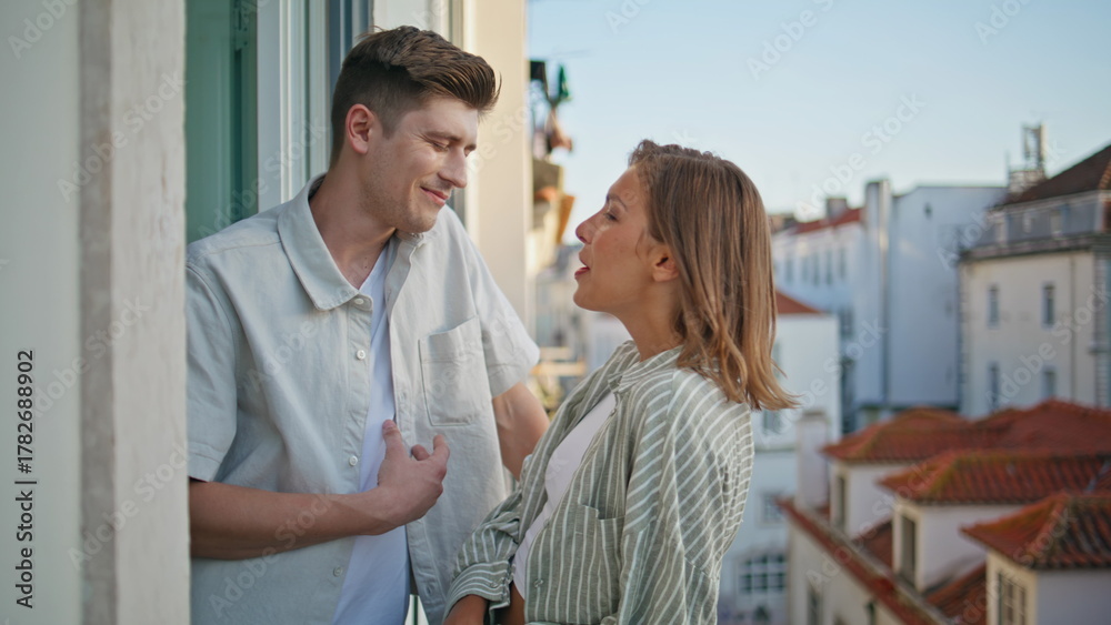 Obraz premium Couple enjoying urban date in evening. Romantic spouses talking on balcony
