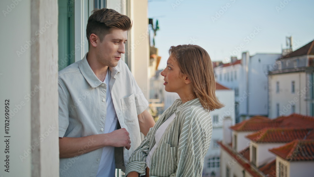 Obraz premium Happy lovers conversing balcony at evening city view. Joyful couple flirting